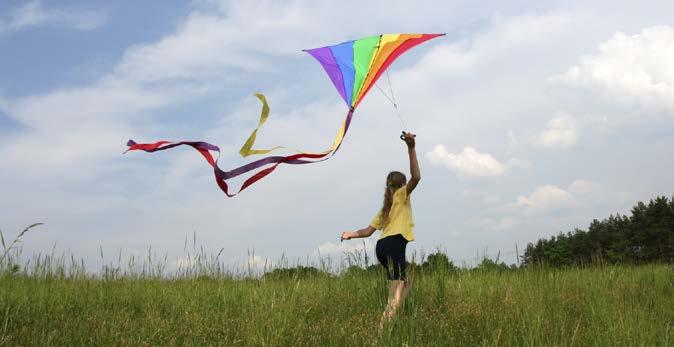 On a breezy day, take your kite to a flat, open area. Be sure that there are no power lines or big trees. Look at the ground around you. Is there anything you could trip over?