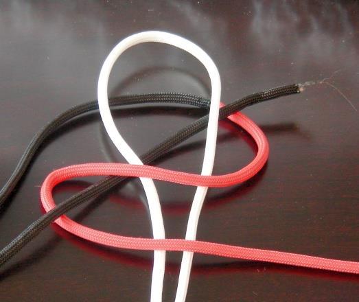 Step 6 As shown in the picture, bring the black cord around and enter the red loop