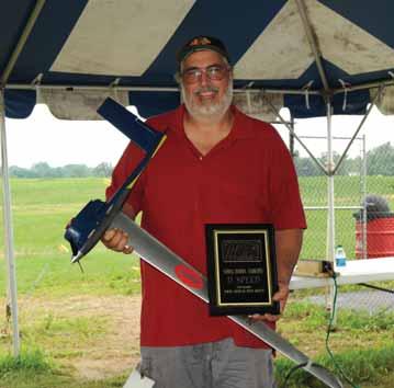 It was very humid, heavy air this morning as several D models are pull tested. Photos by the author. Bill Hughes put up a flight of 180.92 with his OPSpowered model. Next, Chris Montagino turned 170.