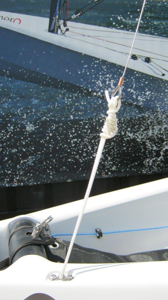 7. Tighten the forestay and secure as shown REMEMBER Check that both ends of the main halyard, jib halyard, and gennaker halyard are tied off at the bottom end of the mast so that they are within