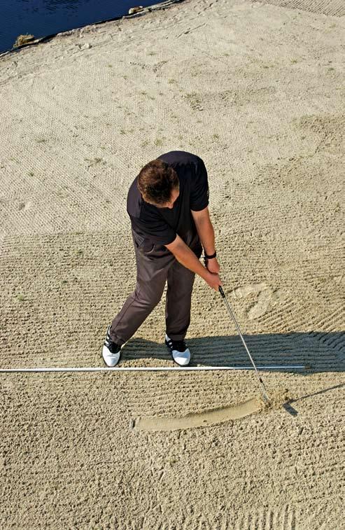 Make sure your eyes are fixed downward all the way and keep your clubhead in the sand through the finish. Observe the arc the club has made in the sand.