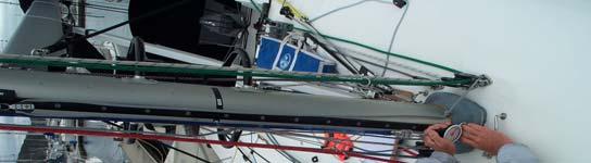 Take the center (Jib) halyard and pull it tight down the front face of the mast.