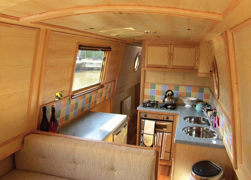 Centre double cabin. Tiles add splash of colour to galley. by the front door, in a very attractive stone-backed hearth.