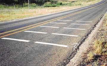 CHAPTER 2 LITERATURE REVIEW IN-LANE RUMBLE STRIPS In-lane rumble strips are grooved or raised patterns on a roadway surface that provide an audible and tactile warning system to motorists approaching
