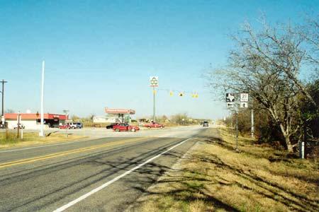 Site 6 is the intersection of SH 21 and FM 2001 near Niederwald, Texas. The intersection is located in Travis County, southwest of Niederwald. The site is at approximately level grade.