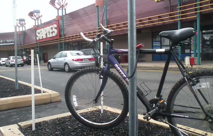 Bikes locked to sign posts at the West Goshen Shopping Center. Bicycle rack at Thorndale rail sta on.