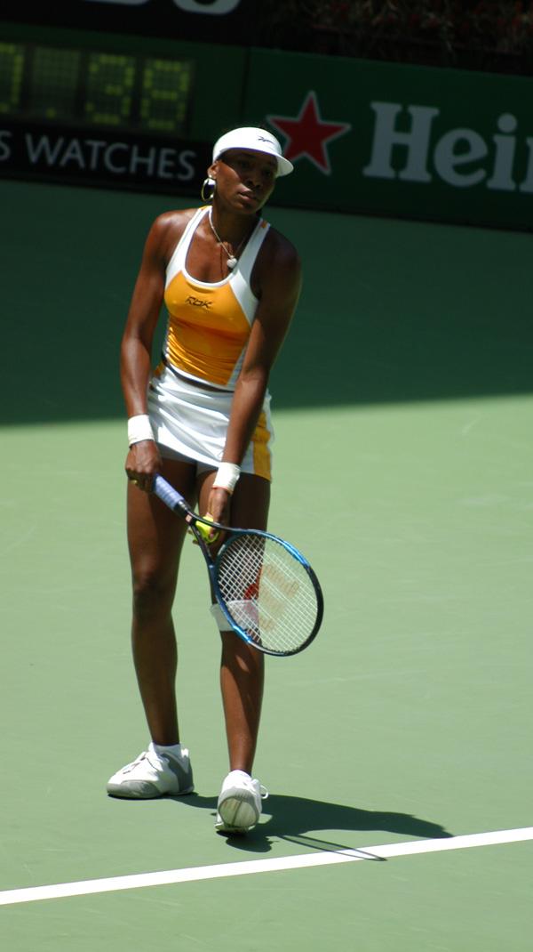 racquet is brought back above the level of the ball. The wrist is kept stiff as contact with the ball occurs in front of the player s body.