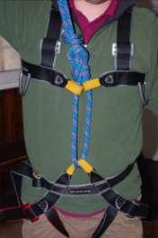 This will either be attached to the belay loop of the sit harness or through both tie-in