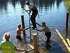 Beaver Deceiver - Installing the Receiver Fence Using a step ladder to pound the corner posts into the substrate with a sledge hammer.
