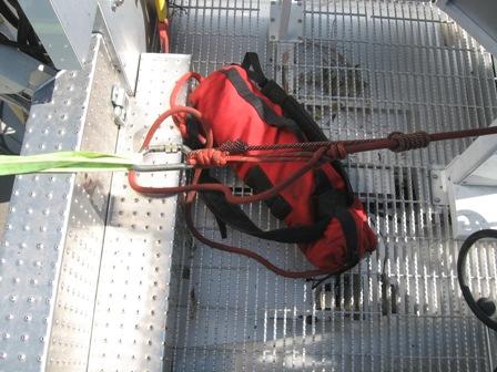 Attach the safety line by using a carabiner and double prusik brake attached to the yellow webbing anchor, as seen in Figure 61, and place the remaining