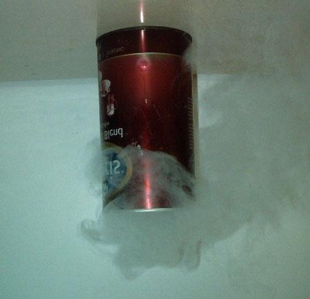 The gas produced continues to heat up inside the tin until it reaches the same temperature as its surroundings (ie room