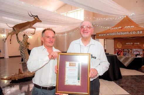 Andrew Conroy receiving an award at the 20 th celebration luncheon from Jan for his support for GAME & HUNT. magazine was born.