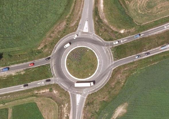 intersections to a 4-armed roundabout. FIGURE 1 Aerial Photographs of two Converted Sites Before and After.