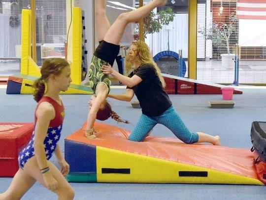 Head coach Kristen Hamlin works with members of the competition team at Head Over Heels Gymnastics on Wednesday, April 4, 2017.