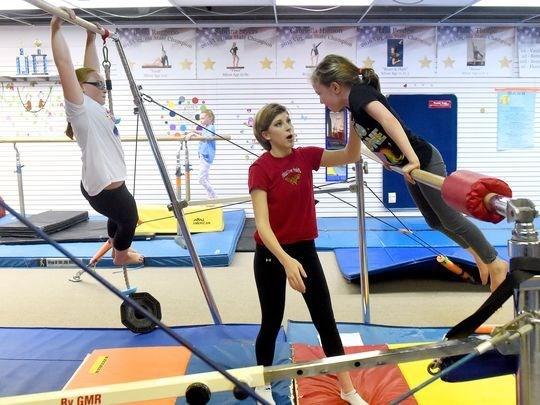 Coach Sarah Beverage works with students in the intermediate 1 and 2 classes at Head Over Heels Gymnastics on Wednesday, April 4, 2017.