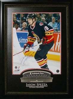 This unique frame features a Jason Spezza hand-signed 16" x 20" game photo with a laser etching of the home stadium and a laser etched description.