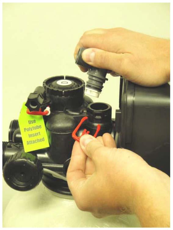 Install the included drain barb assembly to the Clack WS1 Meter Valve by screwing the fitting using a