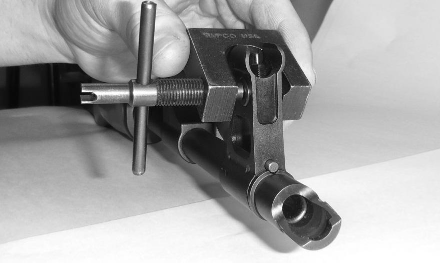 4. Install the recoil spring assembly on the rifle by holding the forward portion of the receiver with one hand, and with your other hand, insert the recoil spring retainer into the bolt carrier