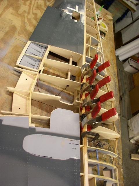 The wing is blocked up under each wing tip to provide the proper dihedral angle. Then the top dihedral brace is glued and clamped.