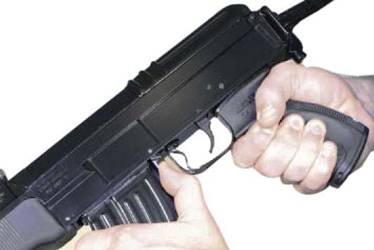 a) Taking out the magazine (Fig. 27): Hold the Compact by the grip panel with the right hand and grasp the front wall of the magazine with the left hand.
