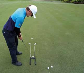 Putt between the two golf clubs or alignment sticks approximately one metre away from the hole.
