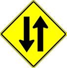 Some communities use Two Way Traffic (W6-3) signs. Some communities created their own signs which attempt to diagram use of the street for unfamiliar drivers.