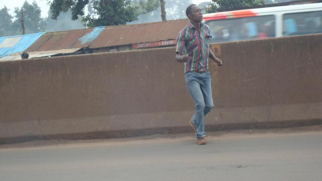 Picture 2: Pedestrians running across the road after climbing over the barrier Source: Author, 2012