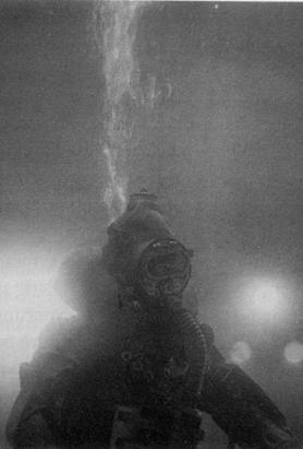 Figure 14. Port Clearance diver with a semi-closed circuit rebreather (18). Figure 15 shows risk estimates for mixed gas diving using the same values as in Fig.