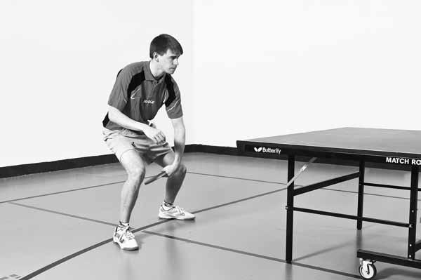 Figure 4.10 Backhand Topspin Stroke Backswing 1. Feet parallel to table 2. Racket side shoulder and hip rotated to be closer to table than nonracket side shoulder and hip 3.