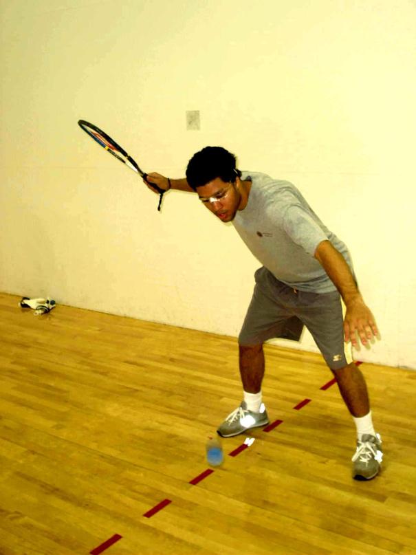 In the backhand stroke, the key point to remember is that the face of the racquet must hit the ball perpendicular to the floor just past the right leg.