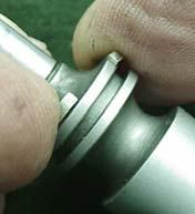 Pry up one end and push ring rearwards of