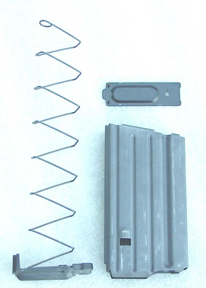 free of magazine body. Note that the base is under spring tension. Figure 2-5b Removing Magazine Base c.