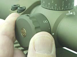b. TARGET/PARALLAX FOCUSING. The day optic has a target focus and parallax adjustment knob on the left side of the scope.