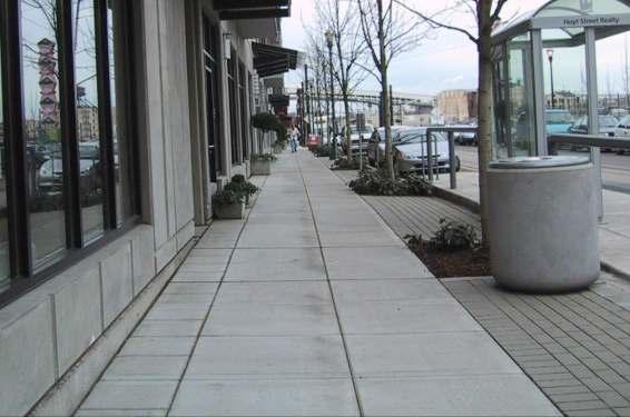 Clear straight sidewalk path with grouping of