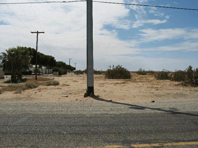 This frontage road had no curbs and the north shoulder consisted of sand, dirt and scattered shrubs.