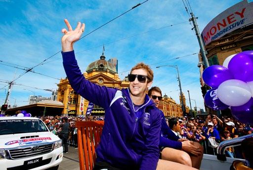 AFL ANNUAL REPORT 2013 COMMERCIAL OPERATIONS DARREN BIRCH 69 Fremantle midfielder Michael Barlow waves to fans outside Flinders St station during the Toyota AFL Grand Final Parade.