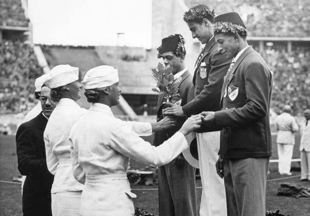 The men s weightlifting winners receive their medals at the 1936 Games in Berlin, Germany. Greece, home of the ancient Olympics, hosted the first modern Olympics in 1896.