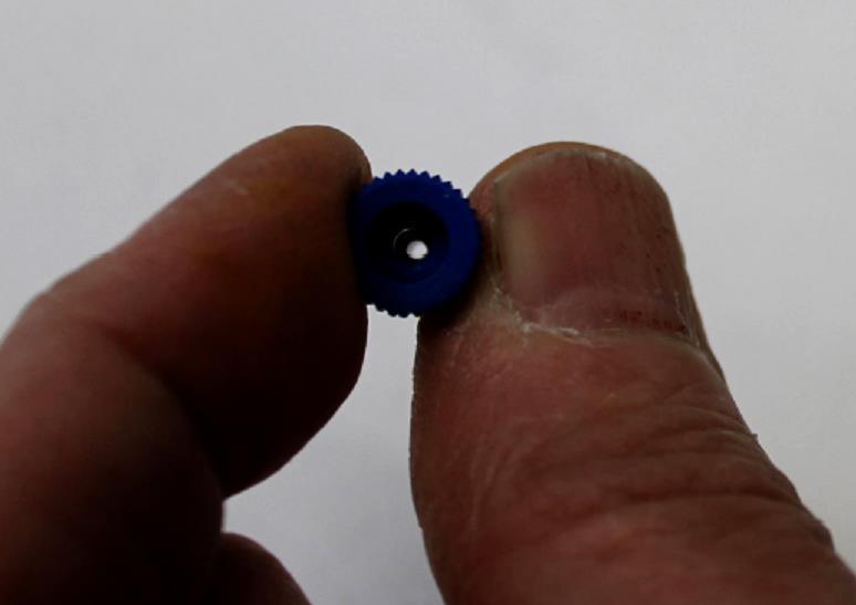 SLOWLY, CAREFULLY AND GENTLY, push the MicroSprayer tip through the hole in the hub of the blue Sprayer Tip Adapter (B).