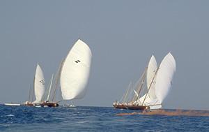 With the orange flares still smoking, three dhows angle for the best start. The one at right has the advantage as its crew has raised two sails, allowing it to catch more wind and sail faster.