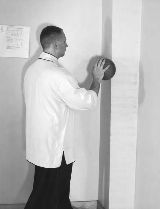 With your palm facing the ball, twist at the waist and roll the ball along the wall until it has moved across your arm to your elbow (Figure 6-23).