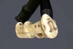 Item number: Fry0081 Item Number: Fry0081 Category: Handle - Drum Handle Materials: Walrus ivory Description: Drum handle of walrus ivory with the face of a woman on the end of the handle.