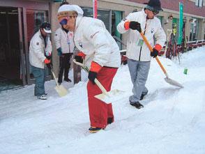 Volunteers clearing snow in early morning (at the Alpine Skiing venue).