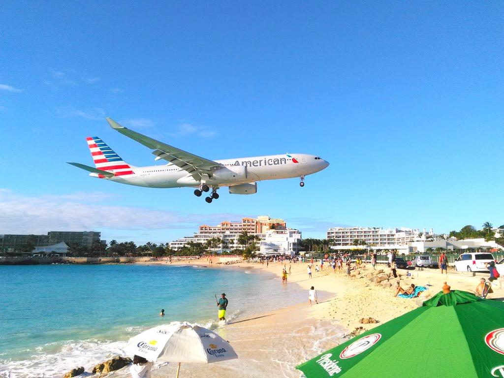 The best thing to do is the stay on the beach just behind the plane that is about to take off, and in the worst case you might fall into the warm water of