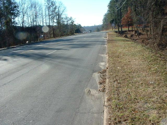 Image 1. Clearly visible longitudinal crack in the asphalt covering a concrete 2-foot wide debris-filled gutter pan. MLK Jr. Blvd., Chapel Hill, NC.