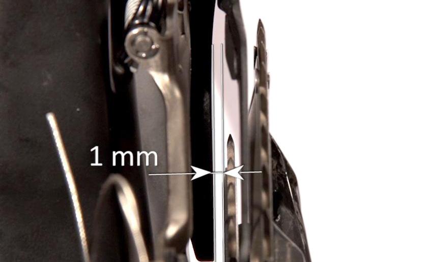 11 8) After locking the front derailleur, check that the fork is always resting against the tool and that the outer edge is parallel to the white line (Fig. 11).