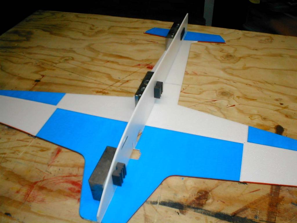 Next, I start to assemble the plane by placing the wing, fuselage and horizontal stab on a flat table with the bottom side facing up.