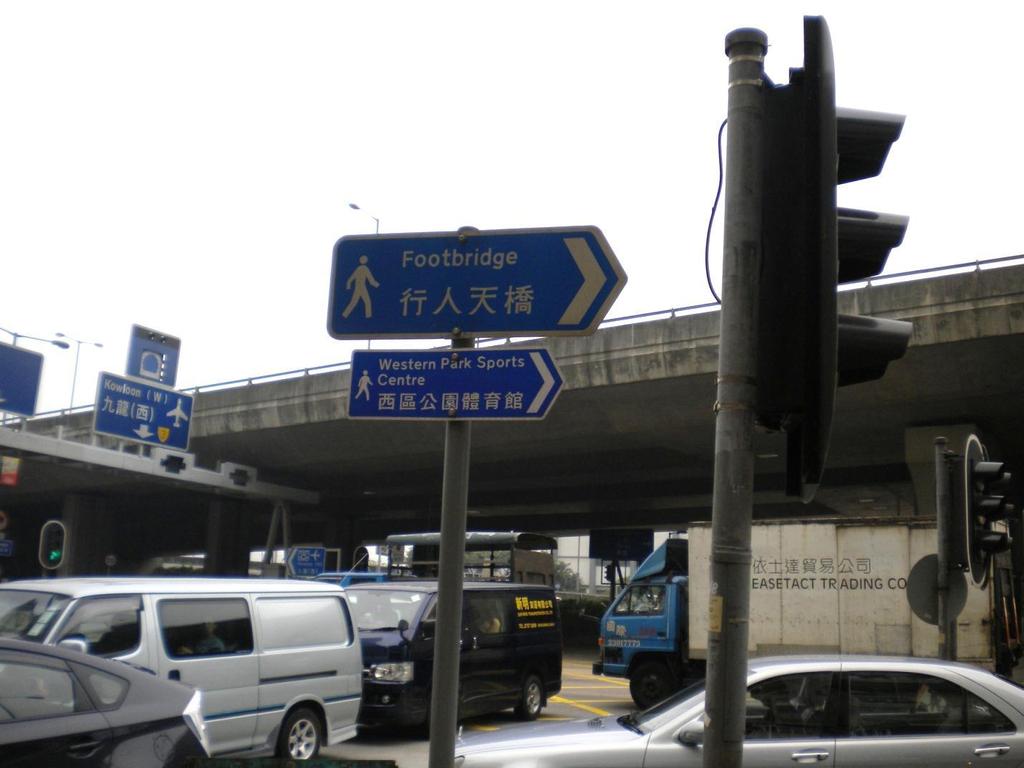 A directional sign, shown in Figure 3.1-6, has a directional arrow, is written in both English and Chinese, and is targeted towards pedestrians.