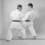 left leg in front. Step in and place your right knee against and behind the left knee of the attacker.