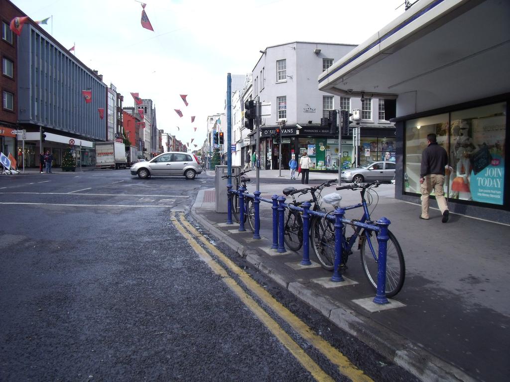 Figure 3 - Bikes parked to street furniture in Limerick city centre (left), and a cyclist crossing the Sarsfield Bridge in the evening peak (right) The cycle-commuter