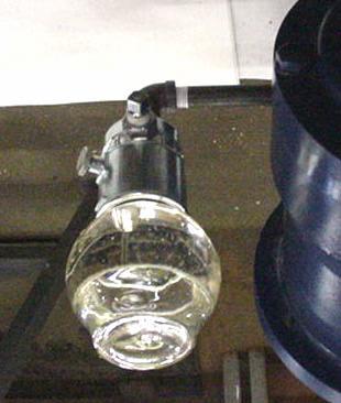Place a finger over the opening of the glass globe assembly and place it onto oiler base assembly with the